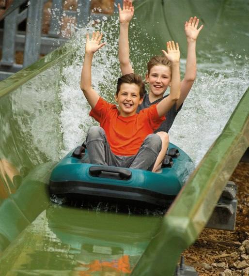 Zwei Jungs brausen mit Bootsrutschen im Freizeitpark Ruhpolding., © Freizeitpark Ruhpolding