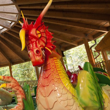 Kleine und große Kinder reiten auf dem Rücken des Drachen im Freizeitpark und Märchenpark Ruhpolding.