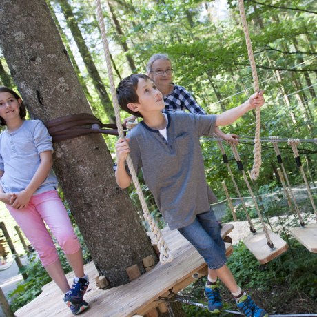 Im Klettergarten im Freizeitpark Ruhpolding sind Trittsicherheit, Konzentration und Kletterfestigkeit gefragt., © Freizeitpark Ruhpolding